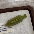 Glossy avocado green minimalist duckbill hair clip with vintage aesthetic on wooden tray - Jelly Color Small No-Trace - Dark Green