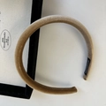 Detailed macro view of khaki velvet headband with a handmade label on the inner side - Brown