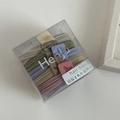 Detailed view of seamless elastic hair bands in Morandi colors inside a transparent box - Box Packaging / Light Multicolor