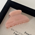 Close-up of a pink acetate hair claw clip with elegant gold lettering on a tray - Pink