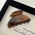 Detailed close-up of brown tortoise shell acetate hair claw clip with French lettering - Dark Coffee
