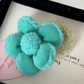 Dettaglio ravvicinato dell'elastico per capelli a fiore in peluche verde menta - Fiore 3D - Elastico Verde