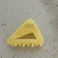 Detail shot of a triangular acetate hair claw clip with Barrette la France lettering - Creamy Yellow