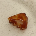 Macro detail of tortoiseshell acetate triangular hair claw clip with La France engraving - Caramel color