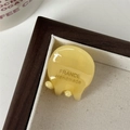 Detail van een mini crèmegele haarklem van acetaat met France Handmade inscriptie - Geel