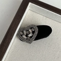 Macro di una molletta a cuore in velluto nero con strass di lusso su vassoio di tela - Floccato Strass Bordo Cuore Completo