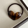 Detailed close-up of tortoise shell resin heart charm hair tie with France handmade engraving - Brown