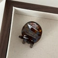 Detail van een schildpad haarklem met gouden France Handmade logo op een dienblad - Blauw Koffie
