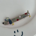 Gros plan sur la pince à cheveux teckel gris avec des pois colorés sur une assiette - Gris à Pois