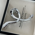 Detail of silver metallic claw clip with twisted design and polished mirror finish - Wave / Silver