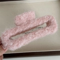 Primo piano di una pinza per capelli in peluche rosa con texture morbida e design rettangolare - Quadrato Svuotato / Rosa chiaro