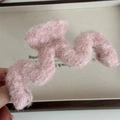 Macro di una pinza per capelli rosa chiaro in peluche con trama soffice in mohair - Molla a M / Rosa chiaro