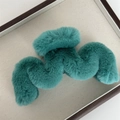 Détail d'une pince à cheveux en fausse fourrure sarcelle avec un design ondulé - Vert malachite