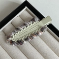 Close-up of knit wool hair clip with multi-color yarn on a green metal duckbill base - White