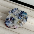 Macro shot of seashell hair claw made of colorful marbled acetate with sparkling rhinestones - Dark Multi-color