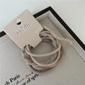 Close-up of earth-toned high elasticity hair bands on minimalist branded packaging card - Beige Woven Texture (5 Pieces Per Card)