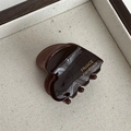 Detailed macro view of small dark brown heart claw clip with golden France Handmade text - Heart Acetate Gold Label - Dark Coffee