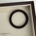 Primer plano de un coletero de espiral negro en una bandeja con textura suave - Marrón Oscuro