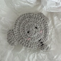 Détail d'une pince à cheveux en crochet gris fait main sur fond blanc texturé - Éléphant