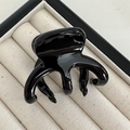 Détail de la pince à cheveux noire brillante aux dents arrondies sur plateau velours - Noir