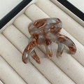 Close-up of brown marble texture hair claw with multi-tooth design in a display box - Green Coffee