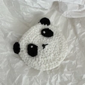 Detailed macro view of hand-knitted panda hair clip with black and white yarn texture - Panda