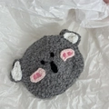 Detailed close-up of a handmade crochet koala hair clip on soft white paper - Koala