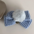 Detail of light blue knit bow hair clip with fluffy grey faux fur ball and gold charm - Blue Bow