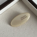 Detailed close-up of acetate oval hair clip with gold France Handmade lettering - Beige