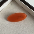 Detailed close-up of handmade amber oval acetate hair clip with France engraving - Orange