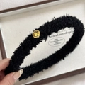 Nahaufnahme der schwarzen Teddy-Plüsch-Haarklammer mit goldenem Smiley-Detail - Schwarzes Smiley-gesicht-stirnband