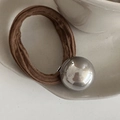 Dettaglio dell'elastico per capelli marrone con sfera d'argento su vassoio bianco - Caffè (Perla Artificiale Extra Large)