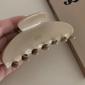 Detailopname van een glanzende beige acetaat haarklem met minimalistisch ontwerp - Beige