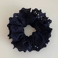 Detail of elegant black lace hair scrunchie with embroidered eyelet design for women - Black