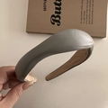Detailed view of grey textured leather wide headband with a beige faux suede inner lining - Gray