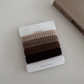 Detailed view of seamless knitted hair ties in earth tones on a display card - Brown