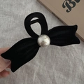 Detailed view of black velvet bow hair claw clip with silver bead on textured fabric - Bow Claw Clip / Black With Champagne Pearl