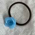 Dettaglio di un fiore di rosa in acetato blu su un elastico per capelli marrone - Blu