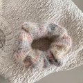 Close-up van zachte kleurrijke pluche scrunchie met pluizige textuur op wit breisel - Kleurrijke Roze Scrunchie - Beige