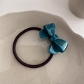 Detailed close-up of dark green acetate bow scrunchie with France Handmade text label - Blue