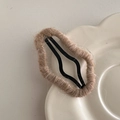 Detail einer mit kaffeebraunem Mohairgarn umwickelten BB-Haarklammer für den Herbststil - Aprikose