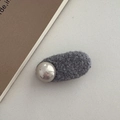 Detail of grey plush faux fur hair clip with a silver metallic pearl accent on a grey surface - Champagne Wide Oval / Gray