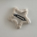 Nahaufnahme einer sternförmigen Haarspange mit grauem Strickgarn und Metall-BB-Clip - Umwickelter Stern / Beige