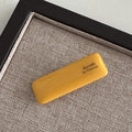 Détail macro d'une barrette rectangulaire jaune moutarde avec lettrage doré La France - Jaune Gingembre