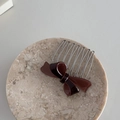 Detail of burgundy bow hair comb with polished acetate finish and silver metal teeth - Dark Coffee