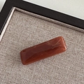 Detailed macro view of the dark amber resin barrette featuring the Barrette la France logo - Brown
