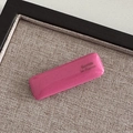 Close-up of a glossy magenta rectangular hair clip with Barrette La France gold lettering - Pink