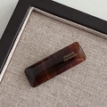 Macro detail of tortoiseshell acetate hair clip with a gold France Handmade logo - Amber