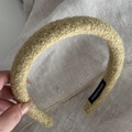 Close-up of olive green handmade headband with soft plush wool texture and inner label - Yellow