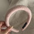 Detail of pink faux shearling headband featuring a woven handmade label on the inner side - Light Pink